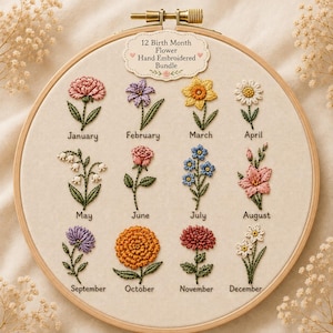 Könnte beinhalten: Ein runder Holzstickrahmen mit einem cremefarbenen Stoffeinsatz, der 12 handgestickte Geburtsblumen zeigt. Jede Blume ist mit dem entsprechenden Monatsnamen in schwarzer Schrift beschriftet. Ein dekoratives Etikett oben trägt die Aufschrift 12 Birth Month Flower Hand Embroidered Bundle.
