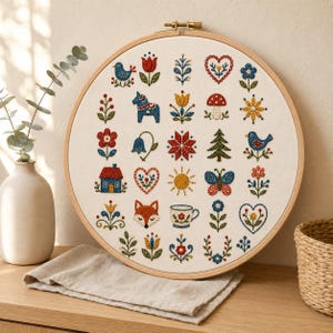 Könnte beinhalten: Ein runder Stickrahmen aus Holz mit weißem Stoff, der ein Raster aus kleinen, bunten Stickmotiven zeigt, darunter Vögel, Blumen, Herzen, ein Fuchs, ein Haus, ein Pilz, ein Schmetterling, eine Sonne, eine Teetasse und ein Dala-Pferd in verschiedenen Farben.