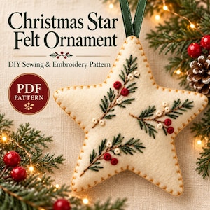 May include: A cream-coloured star-shaped felt ornament featuring embroidered green pine sprigs and red berries, suspended by a dark green ribbon. The text reads Christmas Star Felt Ornament DIY Sewing & Embroidery Pattern PDF PATTERN.