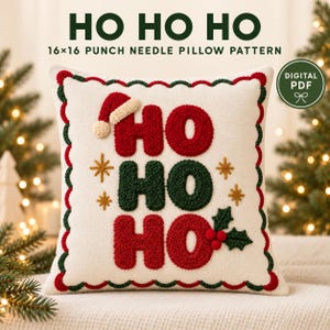 Könnte beinhalten: Ein quadratisches Punch-Needle-Kissenmuster mit dem Text HO HO HO in Rot und Grün, verziert mit einer Weihnachtsmannmütze, goldenen Sternen und Stechpalmenbeeren. Das Design hat einen gewellten rot-grünen Rand auf cremefarbenem Grund, 41x41 cm.