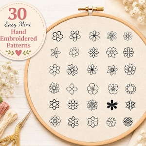 May include: A wooden embroidery hoop containing a cream-colored fabric with 30 black line-art flower patterns arranged in a grid. A circular label reads 30 Easy Mini Hand Embroidered Patterns. Gold scissors and embroidery floss are visible.