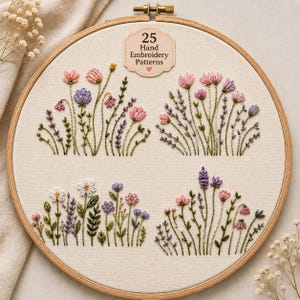 Könnte beinhalten: Ein hölzerner Stickrahmen mit cremefarbenem Stoff, auf dem vier verschiedene Blumenarrangements in rosa, violettem und grünem Garn gestickt sind. Ein Etikett oben zeigt den Text 25 Hand Embroidery Patterns mit einem kleinen Herzsymbol darunter.