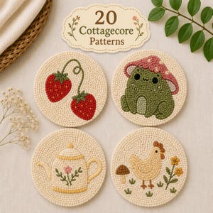 Peut inclure: Quatre sous-verres circulaires en punch needle sur fond crème. Les motifs incluent deux fraises rouges, une grenouille verte avec un chapeau champignon rose, une théière jaune avec une petite fleur et un poulet jaune avec un champignon brun.