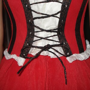 May include: A red dress with black and white trim and a black lace-up corset back.