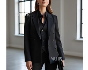 May include: A black suit consisting of a double-breasted blazer, vest, and trousers. The suit is worn with a black collared shirt. The word "NOIR" is visible on the lower right side of the image.