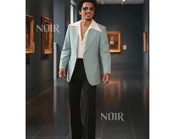 May include: A light blue blazer with a wide lapel, paired with a white shirt and black trousers. The image shows a man wearing sunglasses and a gold ring, walking in a museum. The word "NOIR" is visible in the image.