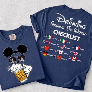 Könnte beinhalten: Ein marineblaues T-Shirt mit einer Grafik eines Cartoon-Mauskopfes, der eine Sonnenbrille trägt und einen Bierkrug hält. Auf der Rückseite des T-Shirts steht der Text Drinking Around The World CHECKLIST mit einer Liste von Ländern und flaggenmusterartigen Maus-Symbolen.