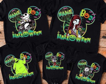 May include: A collection of five black t-shirts and one black baby bodysuit featuring Nightmare Before Christmas characters. Each garment displays a Mickey Mouse ear silhouette containing character graphics, the word NAME, BOO, and HALLOWEEN.