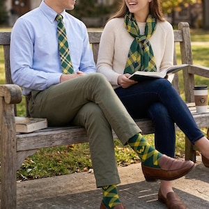 May include: A couple sitting on a wooden bench, wearing matching green and yellow plaid accessories. The man wears a light blue button-down shirt, green pants, and a tie. The woman wears a cream sweater, dark blue jeans, and a scarf. Both wear socks with the same plaid pattern.