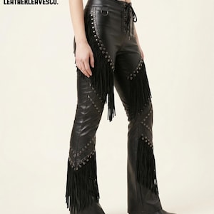 May include: Black leather trousers with fringe detailing and silver stud accents. The trousers have a lace-up front and are flared at the bottom. The brand name "LEATHERLEAVESCO." is visible in the upper left corner.