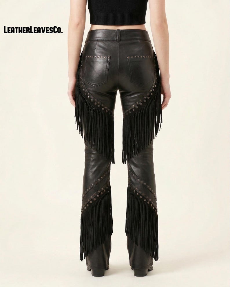 May include: Black leather trousers featuring fringe trim and stud embellishments. The design includes a five-pocket style and a straight leg cut. The text "LEATHERLEAVESCO." is displayed in the top left corner.