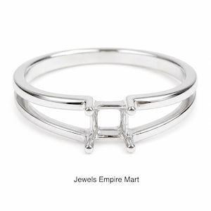 Könnte beinhalten: Ein silberner Ring mit quadratischer Fassung, zur Aufnahme eines Edelsteins. Der Ring hat ein geteiltes Schaftdesign mit zwei parallelen Bändern, die sich an der Fassung treffen. Der Text "Jewels Empire Mart" befindet sich darunter.