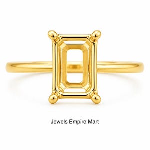Könnte beinhalten: Ein polierter Gelbgold-Ring mit einem rechteckigen Kopf und vier Krappen, der zur Aufnahme eines Edelsteins konzipiert ist. Die Ringschiene ist glatt und rund. Der Text Jewels Empire Mart steht unter dem Ring auf weißem Grund.