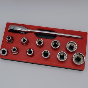 Puede incluir: Un juego de llaves de vaso cromadas y una llave de carraca dispuestas en una bandeja roja. Las llaves de vaso tienen aberturas hexagonales y cuadradas. La llave está en la parte superior de la bandeja.