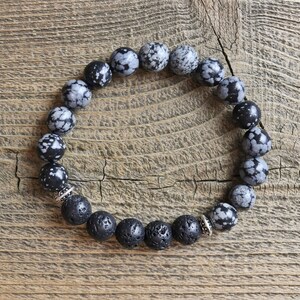 May include: A black and white snowflake obsidian bracelet with black lava rock beads and silver spacers.