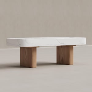 May include: A rectangular coffee table with a white marble top and two wooden supports. The table's top has subtle gray veining. The wooden supports are a light brown color.