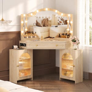 May include: A light wood vanity table featuring an arched mirror with integrated LED bulbs, a central drawer with two gold knobs, and two side cabinets with fluted glass doors. The unit includes built-in power outlets and storage shelves.