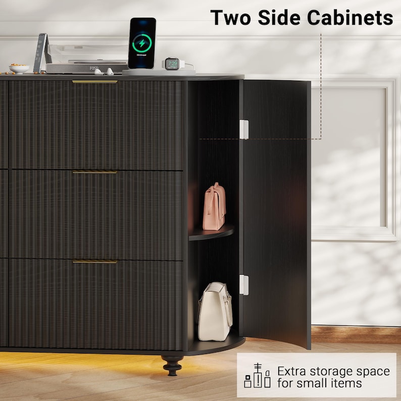 May include: Black two-door side cabinet with three drawers and gold-colored handles. The cabinet has a textured, vertical-lined design. The open door reveals a shelf with a pink purse and a white purse. The text reads "Two Side Cabinets" and "Extra storage space for small items."
