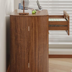 May include: A wooden cabinet with a curved top and two doors. The cabinet has a drawer that is partially open, revealing the contents. The wood has a natural grain pattern. The cabinet is in a room with a window.