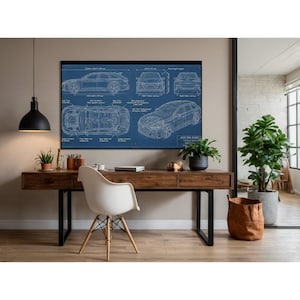 Op de afbeelding: Een ingelijste blauwdruk van een auto, met meerdere aanzichten en technische details, hangt boven een houten bureau. De blauwdruk is wit op een blauwe achtergrond. Het bureau heeft een witte stoel en is versierd met planten.