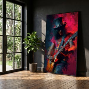 May include: A framed art print depicting a guitarist playing a red electric guitar, set against a backdrop of red, pink, and blue hues. The musician wears a top hat and sunglasses. The artwork is displayed in a room with a window and a potted plant.