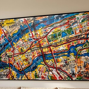May include: Abstract painting of a map of New York City with a black frame. The map features a colorful design with red, yellow, blue, and white hues. Text includes "NYHC", "Hudson River", "Broadway", and "Gotham".