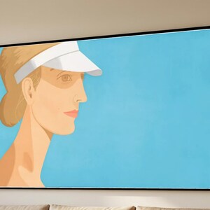May include: A framed art print featuring a woman in profile wearing a white visor against a light blue background. The woman has blonde hair and fair skin. The artwork is displayed in a black frame.