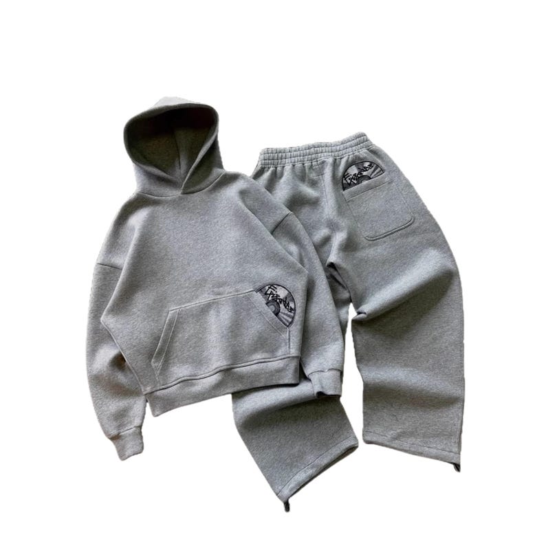 Puede incluir: Un conjunto de sudadera con capucha y pantal&oacute;n de ch&aacute;ndal grises. La sudadera tiene un bolsillo delantero y una capucha. El pantal&oacute;n de ch&aacute;ndal tiene un bolsillo en la parte trasera. Ambas piezas tienen un peque&ntilde;o dise&ntilde;o bordado. El conjunto es de material suave y c&oacute;modo.