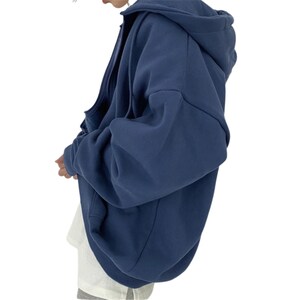 May include: A navy blue zip-up hoodie with a hood. The hoodie is made of a soft material and has a relaxed fit. The sleeves are long and the overall style is casual.