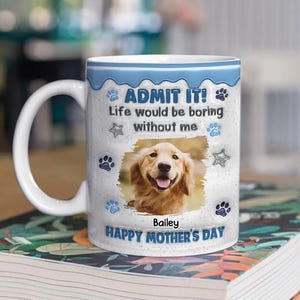 May include: White ceramic mug with a blue rim and handle. The mug features a photo of a golden retriever, paw prints, and the text "ADMIT IT! Life would be boring without me" and "HAPPY MOTHER'S DAY".