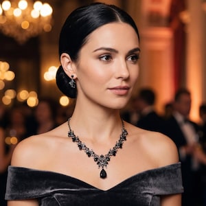 May include: A necklace and earring set featuring dark, faceted stones set in a metallic frame. The necklace has a central teardrop-shaped pendant with smaller leaf-like accents along the chain, and the earrings are matching drop-style pieces.
