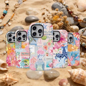 May include: Five phone cases with vibrant beach-themed designs. The cases display illustrations of seashells, flowers, and nautical elements. Some cases have text that reads "Key West" and "Coastal Life". The cases are on a sandy surface.