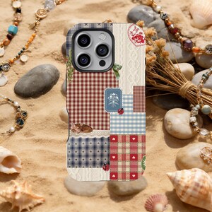 May include: A patchwork phone case with a mix of patterns like gingham and cable knit, in red, blue, and white. It includes a deer illustration and ladybug details. The case is set against a backdrop of sand and decorative jewelry.