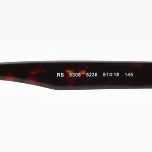 May include: Close-up of the arm of a pair of eyeglasses. The arm is a dark brown tortoiseshell pattern. White text reads "RB 5308 5236 51 18 145". The glasses are likely for vision correction or sun protection.