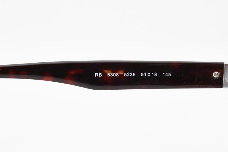 May include: Close-up of the arm of a pair of eyeglasses. The arm is a dark brown tortoiseshell pattern. White text reads "RB 5308 5236 51 18 145". The glasses are likely for vision correction or sun protection.