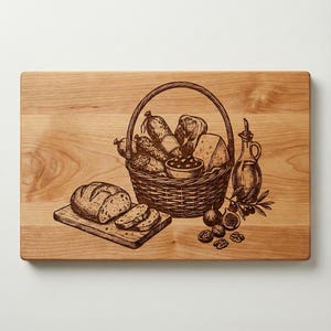 Può includere: Un tagliere in legno con un'incisione dettagliata di una scena da picnic. Un cesto pieno di pane, formaggio e salsiccia è presente, insieme a una pagnotta di pane, olive, fichi, noci e una bottiglia di olio d'oliva.