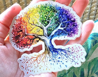 Op de afbeelding: Een kleurrijke regenboogboom sticker met een witte stam en wortels. De bladeren zijn geschilderd in tinten rood, oranje, geel, groen, blauw, indigo en violet.