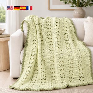 May include: A pale green crochet throw blanket featuring vertical stripes of openwork fan patterns and solid textured stitches. The blanket has a scalloped border in a slightly darker shade of green, creating a decorative edge finish.