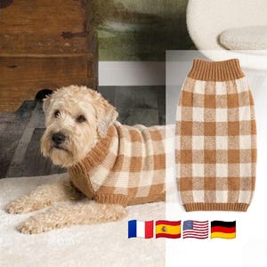 May include: A dog jumper featuring a tan and cream-coloured gingham check pattern. The garment has a ribbed knit collar and hem, constructed from a soft knit material. The design includes a consistent checkered motif across the entire surface.