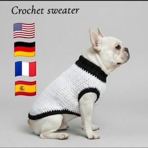 Può includere: Un maglione bianco all'uncinetto per cani con bordi neri. Il testo "Crochet sweater" è visibile. Il cane è un bulldog francese bianco.