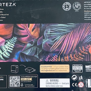Puede incluir: Una caja de 36 rotuladores artísticos Arteza EverBlend, Flora Tones, con un diseño de hojas tropicales coloridas. La caja incluye el texto "Premium", "Mezclable", "Tinta a base de alcohol" y "Doble cara". La caja está diseñada en EE. UU.