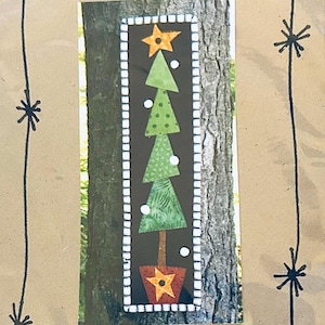 Pode incluir: Uma tapeçaria retangular com a ilustração de uma árvore de Natal estilizada sobre um fundo preto. A árvore é composta por quatro segmentos triangulares verdes com vários padrões, rematada com uma estrela laranja e num vaso castanho.
