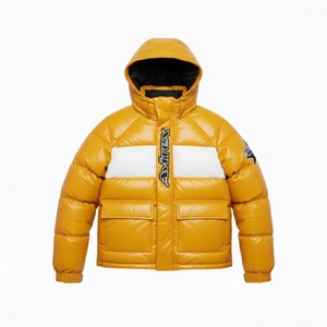 May include: Mustard yellow puffer jacket with a hood and two front pockets. The jacket features a white stripe across the chest with the brand name in black. A small logo is on the upper left sleeve. The jacket is designed for cold weather.