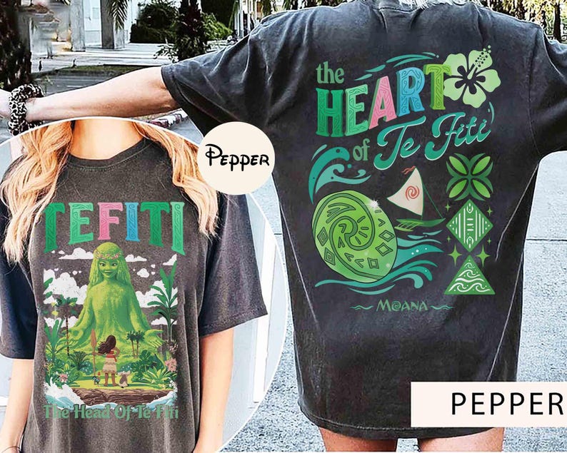 May include: Dark gray t-shirt featuring the text "TEFITI" in green, pink, and blue. The front graphic depicts a green goddess figure and a small girl on an island. The back of the shirt has the text "the HEART of Te Fiti" with related graphics.