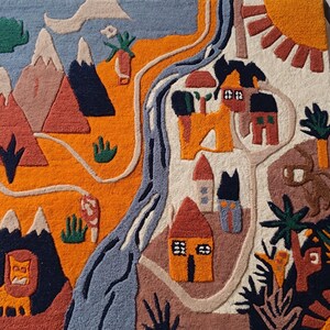 May include: A rectangular tufted rug featuring a landscape design with mountains, a winding blue river, and small houses. The scene includes a lion, palm trees, and a sun in vibrant colors of orange, blue, brown, and cream, creating a textured surface.