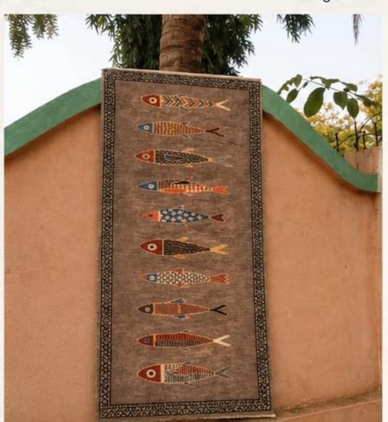 May include: A rectangular rug with a textured brown background featuring ten horizontally aligned fish motifs in various colors including red, blue, orange, and yellow. The rug is framed by a dark border with a repeating white geometric pattern.
