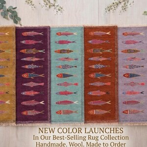 Pode incluir: Uma coleção de tapetes retangulares coloridos, cada um com um padrão repetido de peixes estilizados. Os tapetes vêm em várias cores, incluindo dourado, roxo, verde-azulado, castanho, lavanda e preto. Os tapetes são feitos de lã e têm uma borda com franjas. O texto "NEW COLOR LAUNCHES" é visível.