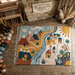 May include: A rectangular tufted rug featuring a colorful landscape scene with mountains, a winding blue river, a small village with houses, a lion, a monkey, palm trees, and a yellow sun, finished with white fringe on the top and bottom edges.