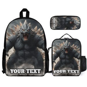May include: A black backpack, a rectangular pencil case, and a square lunch bag, each featuring a graphic of a dark, muscular, spiky monster with glowing red eyes and the text YOUR TEXT printed in bold white letters on the front of each item.