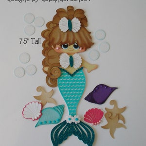 May include: A 7.5 inch tall mermaid craft with brown hair, a turquoise tail, and a white bow. The craft includes seashells, starfish, and bubbles.